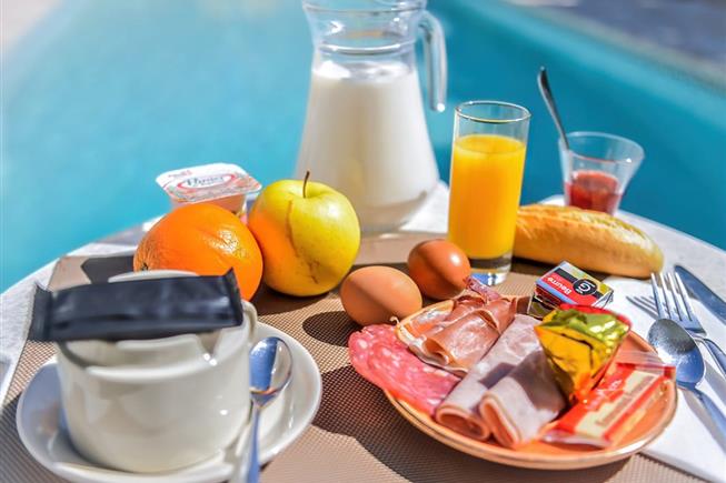 Petit-déjeuner au bord de la piscine extérieure de l'Hôtel Résidence à Nissan-Lez-Ensérune