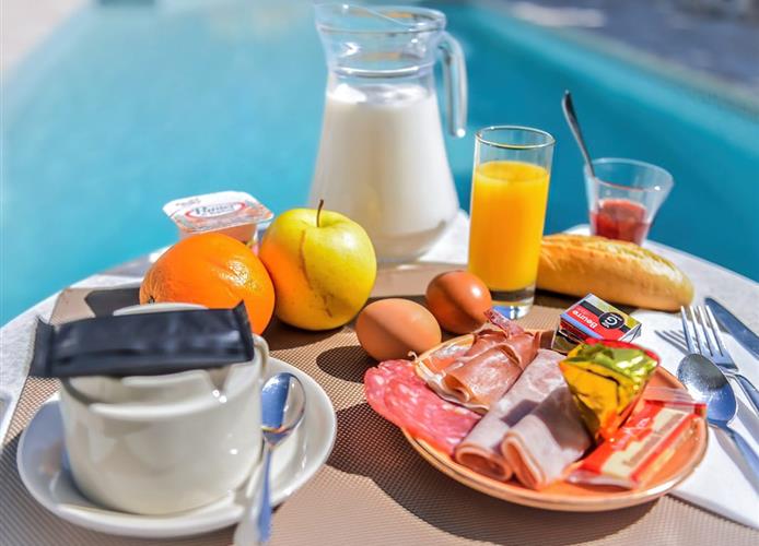 Petit-déjeuner au bord de la piscine extérieure de l'Hôtel Résidence à Nissan-Lez-Ensérune