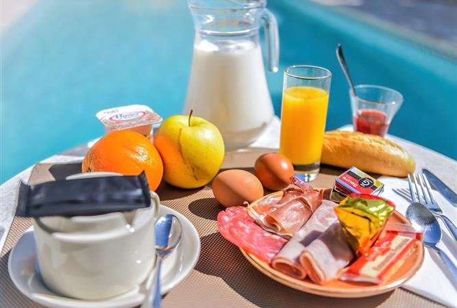 Petit déjeuner sur la terrasse au bord de la piscine